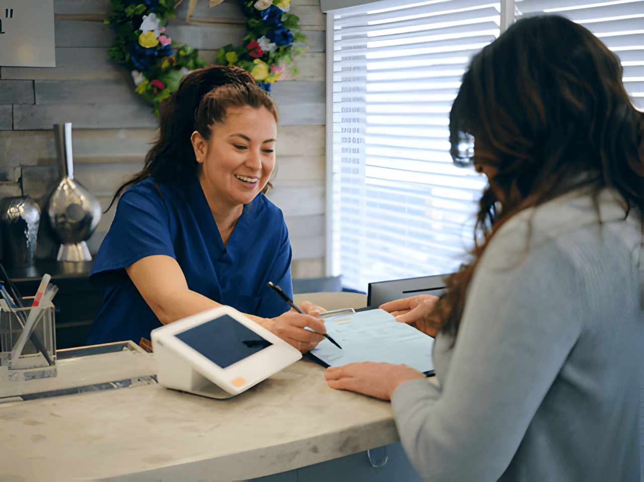 Patient and staff in a healthcare practice. Streamlined payments with Payment Bridge via Omega