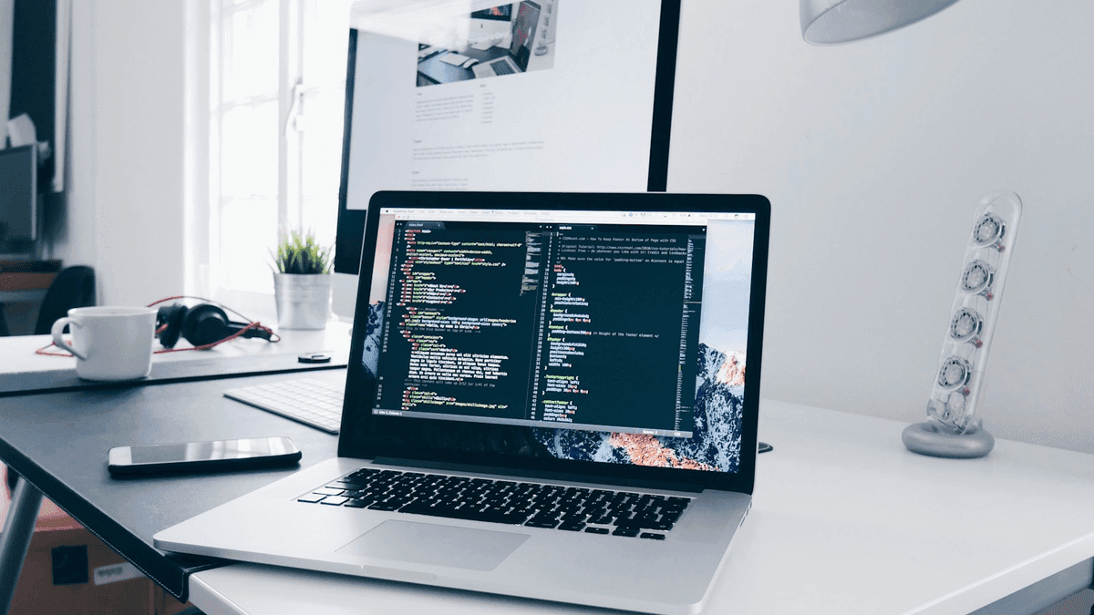 Developer laptop with website code, building a payment-ready business website