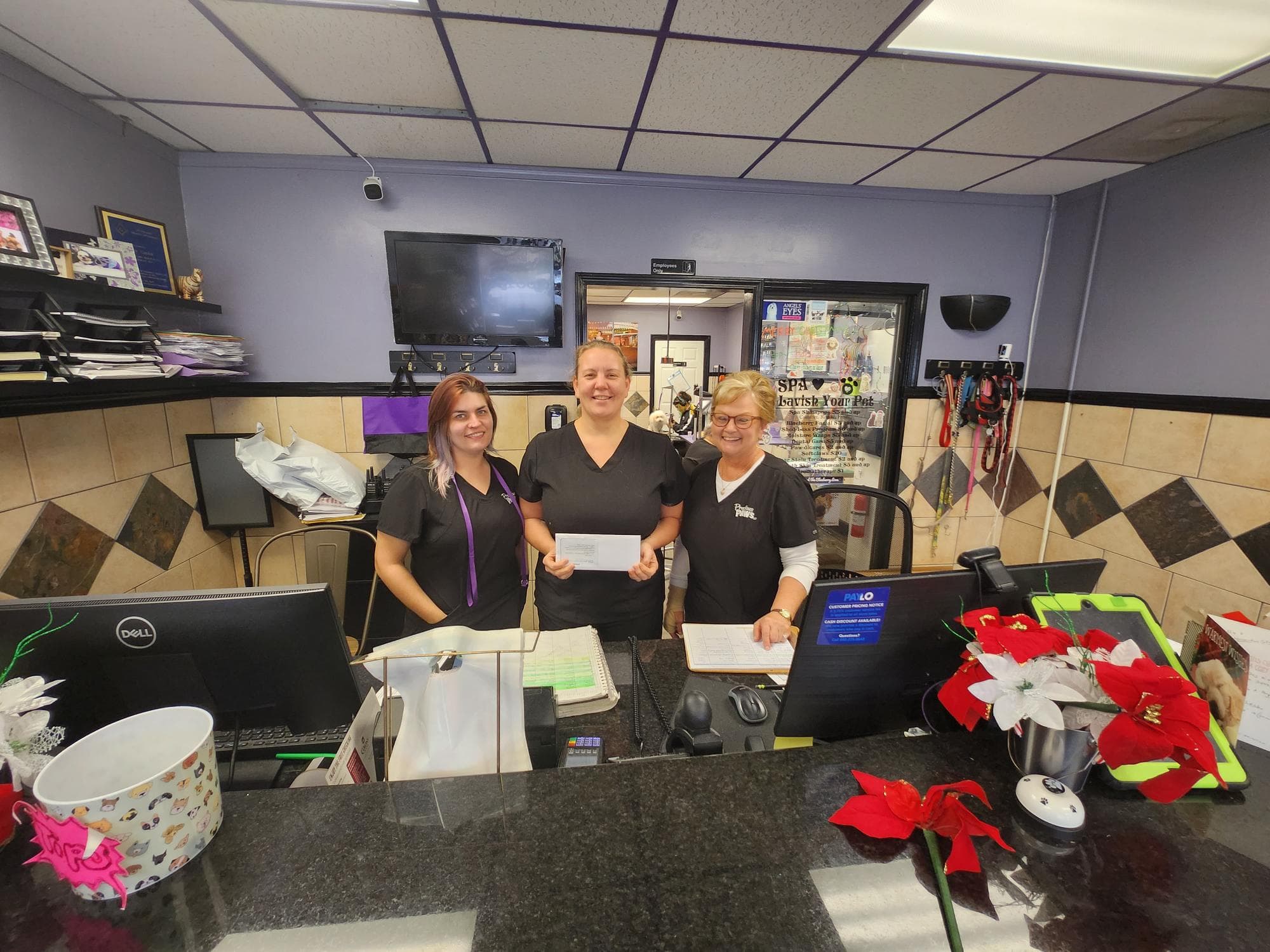 Pet spa staff at reception with rewards envelope, Omega rewards program partner, Acworth, Georgia