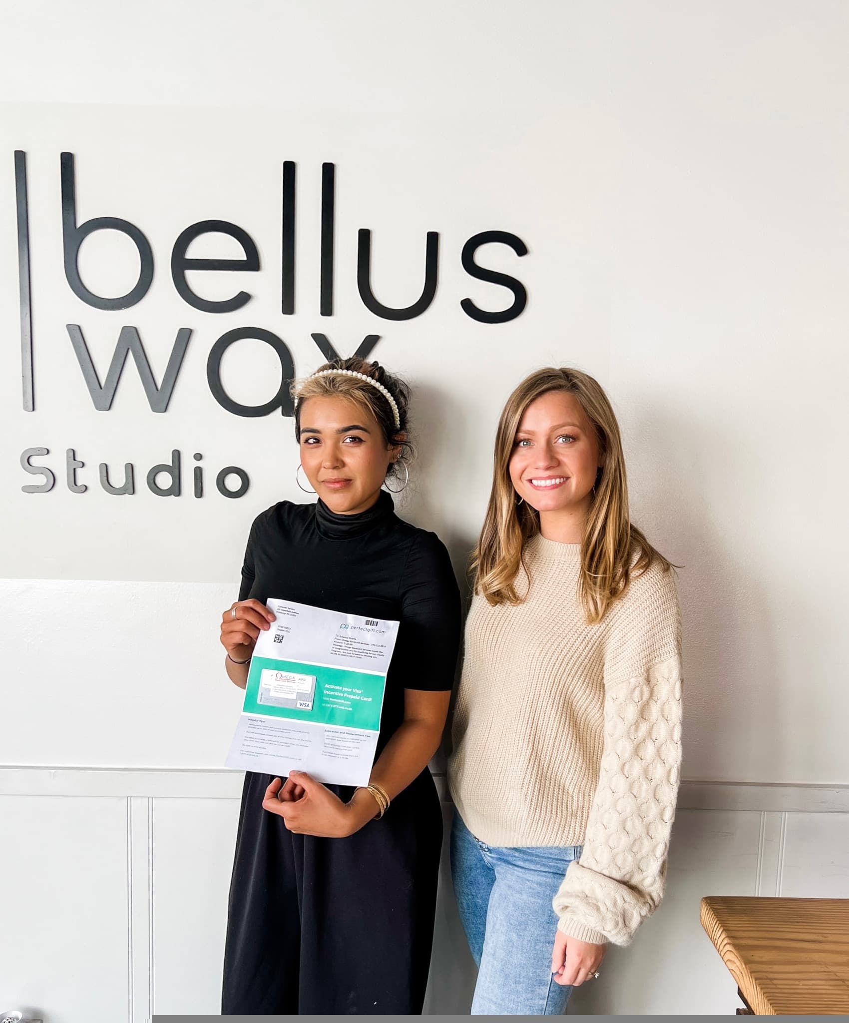 Merchant partners with Omega rewards program materials and prepaid incentive card at their business, Americus, Georgia